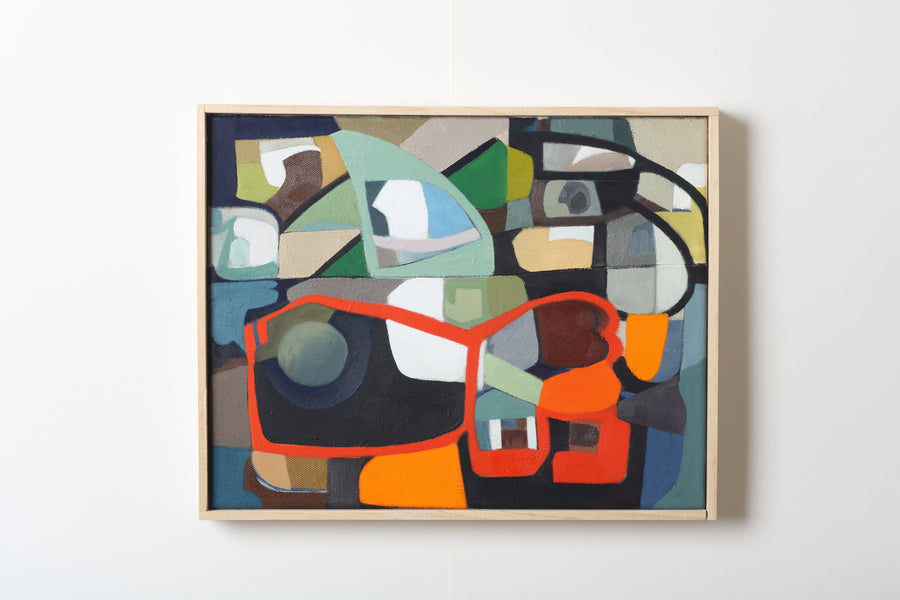Abstract art piece with colorful geometric shapes in a wooden frame on a white wall
