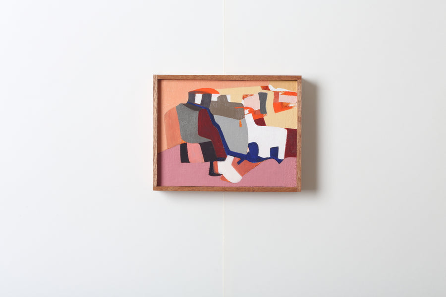 Abstract art piece with colorful shapes in a wooden frame on a white wall