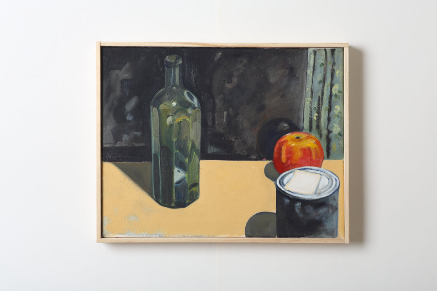 Framed still life painting with a bottle, apple, and can on a yellow surface.